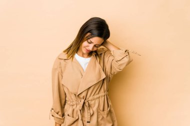 Bej arka planda izole edilmiş genç bir kadın stresten dolayı boynu ağrıyor, masaj yapıyor ve elle dokunuyor..