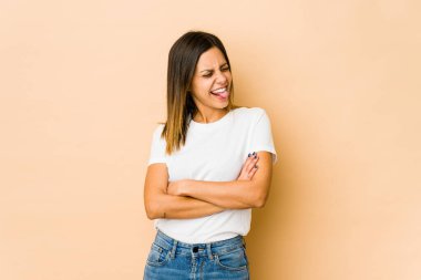 Bej arka planda izole edilmiş genç bir kadın komik ve dost canlısı bir dil uzatıyor..