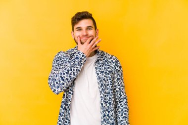 Kafkasyalı genç, sarı arka planda izole edilmiş, iki seçenek arasında şüphe duyuyor..