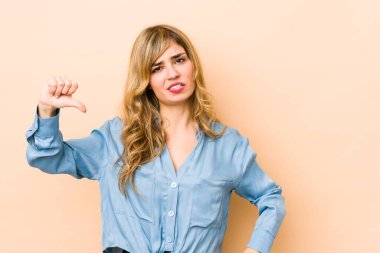 Sarışın, beyaz bir kadın baş parmağını aşağı gösteriyor ve hoşlanmadığını söylüyor..