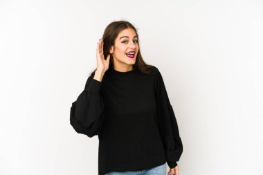 Beyaz arka planda izole edilmiş genç beyaz kadın bir dedikoduyu dinlemeye çalışıyor..