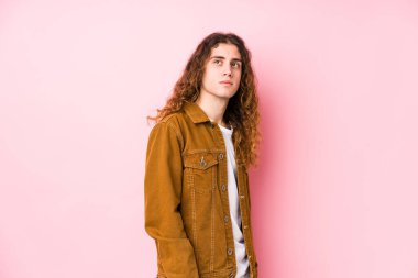 Genç, uzun saçlı, yalnız poz veren, gülümseyen, neşeli ve keyifli bir adam..