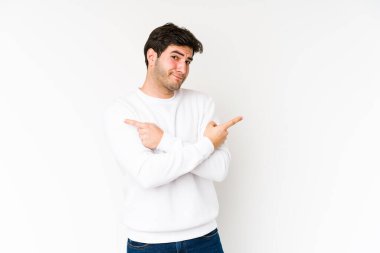 Beyaz arka plan noktalarından izole edilmiş genç adam iki seçenek arasında seçim yapmaya çalışıyor..