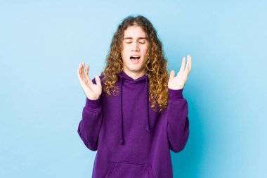 Uzun saçlı adam neşeli poz veriyor. Çok gülüyor. Mutluluk kavramı.