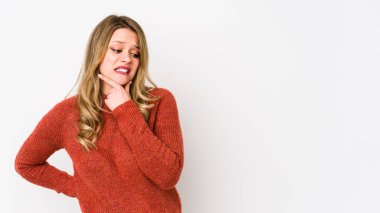 Beyaz arka planda soyutlanmış beyaz tenli bir kadın kafasının arkasına dokunuyor, düşünüyor ve bir seçim yapıyor..