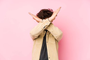 Arka planda poz veren genç bir Arap adam iki kolu çapraz tutuyor, inkar kavramı.