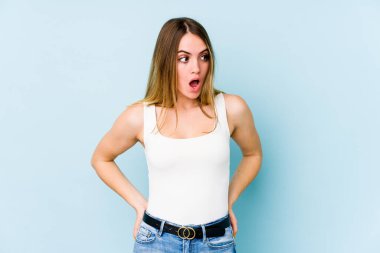 Mavi arka planda izole edilmiş beyaz bir kadın gördüğü bir şey yüzünden şoka uğruyor..