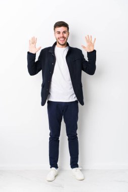 Tam vücut genç beyaz adam izole edilmiş. Elleriyle on numarayı gösteriyor..