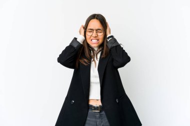 Genç melez iş kadını beyaz arka planda izole edilmiş kulakları elleriyle kapatıyor..