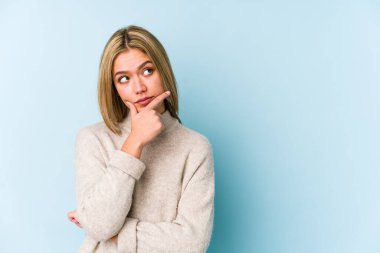 Sarışın, beyaz tenli, yanlamasına kuşkuyla bakan bir kadın..