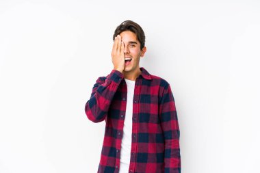 Pembe arka planda poz veren beyaz bir genç. Yüzünün yarısını palmiye ile kaplayarak eğleniyor..