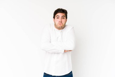 Beyaz arka planda izole edilmiş genç adam omuz silkiyor ve gözleri açık..