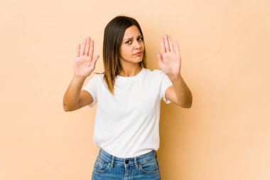 Bej arka planda izole edilmiş genç bir kadın elini uzatmış, dur işareti göstererek seni engelliyor..