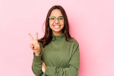 Genç, melez, Latin bir kadın iki numarayı parmaklarıyla gösteriyor..