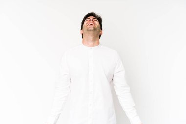 Beyaz arka planda izole edilmiş genç adam rahat ve mutlu bir şekilde gülüyor, boynunda dişlerini gösteriyor..