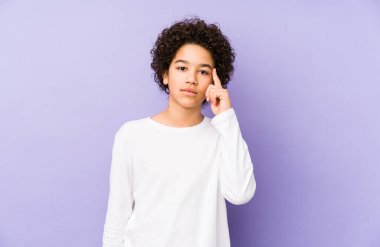 Afrika kökenli Amerikalı küçük çocuk tapınağı parmağıyla göstererek bir göreve odaklandı..