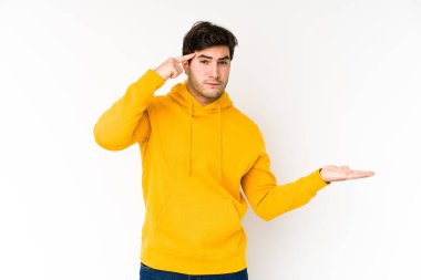 Beyaz arka planda izole edilmiş genç bir adam elinde bir ürün tutuyor..