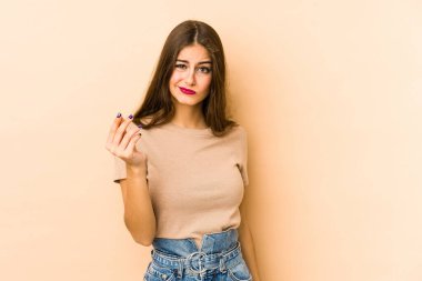 Beyazlı genç bir kadın bej arka planda izole edilmiş. Parası olmadığını gösteriyor..