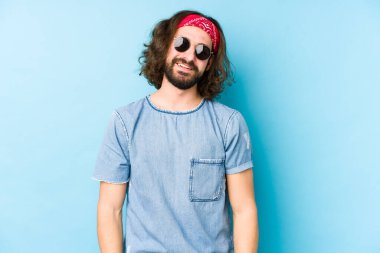 Genç, uzun saçlı, festival hippisi gibi giyinmiş mutlu, güler yüzlü ve neşeli görünüyor..