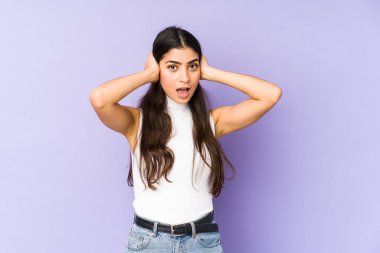 Genç Hintli kadın mor arka planda izole edilmiş bağırıyor, çok heyecanlı, tutkulu, bir şeyden memnun..