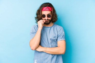 Genç, uzun saçlı, festival hippisi gibi giyinmiş. Parmakları dudaklarında ve bir sırrı saklıyormuş..