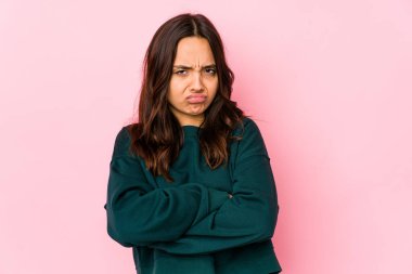 Latin kökenli genç bir kadın hoşnutsuzca kaşlarını çatmış, kollarını kavuşturmuş..