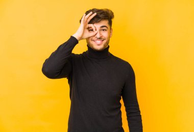 Sarı arka planda izole edilmiş genç bir Arap heyecanlı..