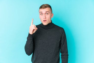 Mavi arka planda genç beyaz bir adamın bir fikri, ilham konsepti var..