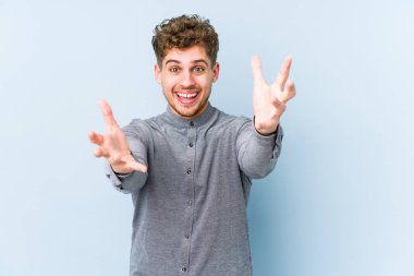 Sarışın, kıvırcık saçlı, yalıtılmış beyaz adam kameraya sarılıyor..