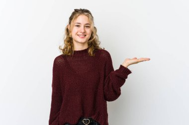 Beyaz arka planda beyaz tenli genç bir kadın bir avuç içinde fotokopi alanı gösteriyor ve belinde başka bir el tutuyor..