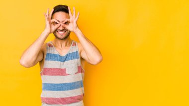 Kafkasyalı genç adam sarı fırında izole edilmiş. Heyecanlı. Göze göz hareketi yapıyor..