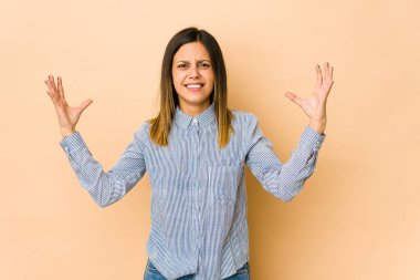 Bej arka planda izole edilmiş genç bir kadın öfkeyle bağırıyor.