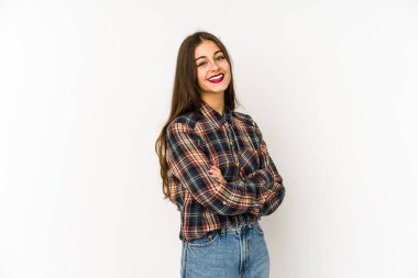 Beyaz arka planda kendini güvende hisseden, kararlılıkla kollarını kavuşturan beyaz tenli genç bir kadın..