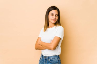 Bej arka planda izole edilmiş genç bir kadın şüpheli, belirsiz, seni muayene ediyor..