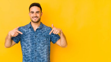 Kafkasyalı genç adam sarı fırında izole edilmiş parmaklarıyla aşağıya bakıyor, olumlu bir his..