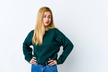 Beyaz arka planda soyutlanmış genç sarışın kadın kafası karışmış, şüpheli ve güvensiz hissediyor..