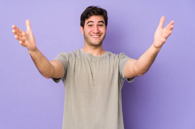Mor arka planda kalan genç adam zaferi ya da başarıyı kutluyor, şaşırıyor ve şok oluyor..