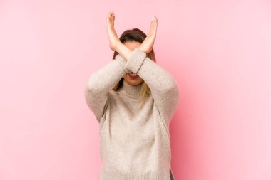 Pembe arka planda izole edilmiş orta yaşlı bir kadın iki kolu çapraz tutuyor, inkar kavramı.
