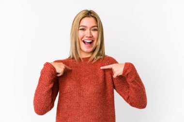 Sarışın, beyaz tenli, izole bir kadın. Parmakla işaret ederek şaşırmış, gülümseyerek..