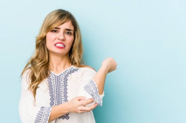 Sarışın, beyaz bir kadın, dirsek masajı yapıyor, kötü bir hareketin ardından acı çekiyor..