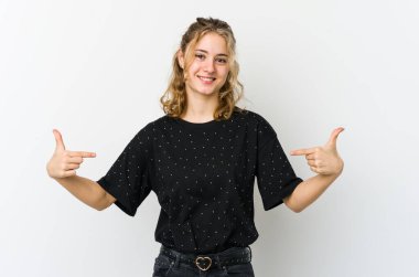 Beyaz arka plandaki genç beyaz kadın parmaklarıyla aşağı işaret ediyor, olumlu bir his..