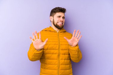 Mor arka planda izole edilmiş genç bir adam tiksinti belirtisi gösteren birini reddediyor..