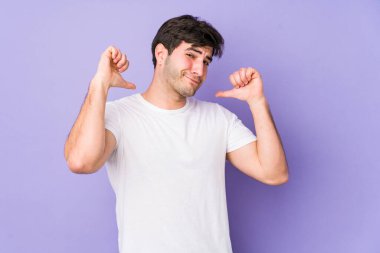 Mor arka planda izole edilmiş genç adam gururlu ve kendinden emin hissediyor, örnek olarak..