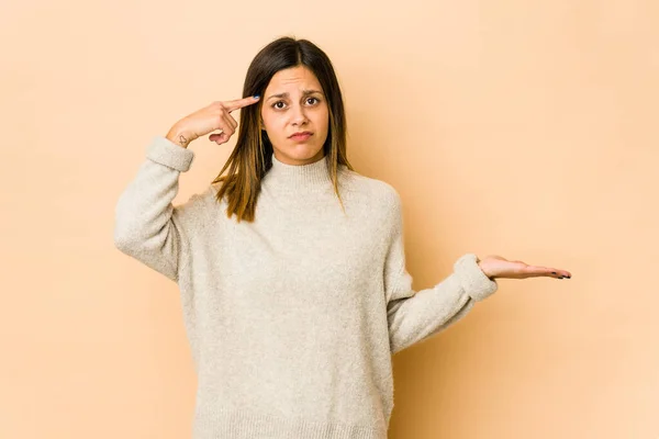 Mujer Joven Aislada Sobre Fondo Beige Sosteniendo Mostrando Producto Mano —  Fotos de Stock