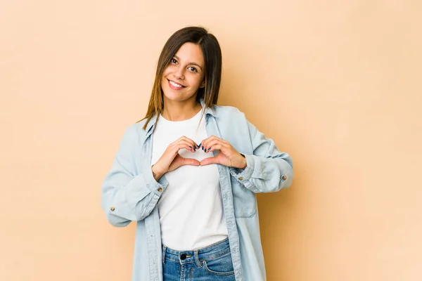 Jovem Mulher Isolada Fundo Bege Sorrindo Mostrando Uma Forma Coração — Fotografia de Stock