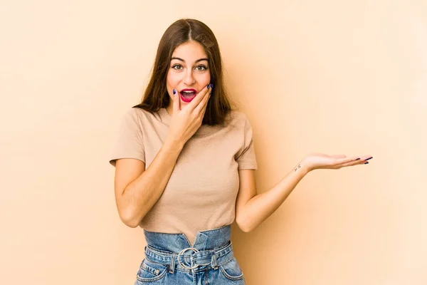 Mulher Caucasiana Jovem Isolado Fundo Bege Detém Espaço Cópia Uma — Fotografia de Stock