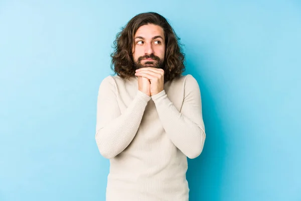 Jovem Homem Cabelo Longo Isolado Fundo Azul Mantém Mãos Sob — Fotografia de Stock