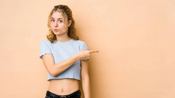 Giovane Donna Caucasica Isolato Sfondo Beige Sorridente Indicando Parte Mostrando — Foto Stock