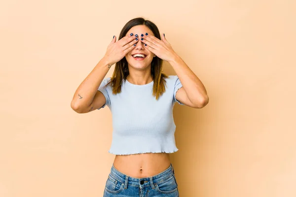 Junge Frau Auf Beigem Hintergrund Bedeckt Augen Mit Händen Lächelt — Stockfoto