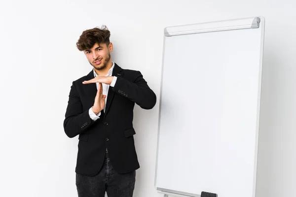 Young business coaching arabian man showing a timeout gesture.